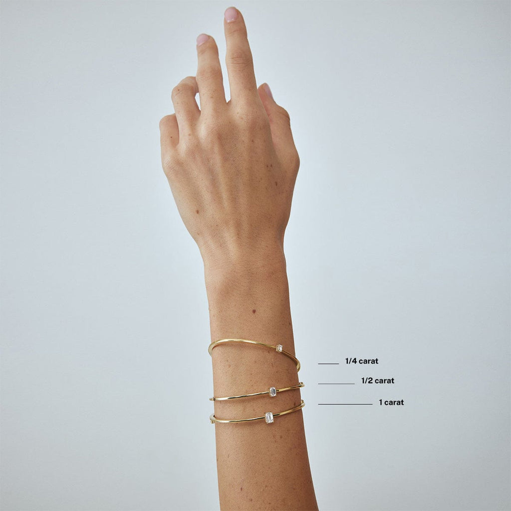 compare emerald diamond carat weight bracelets on model's wrist arm