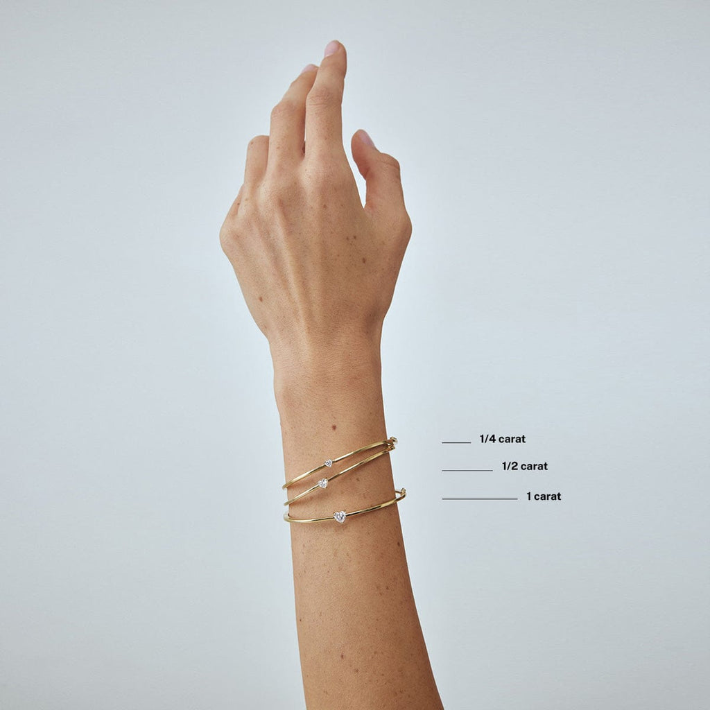 compare heart diamond carat weight bracelets on model's wrist arm
