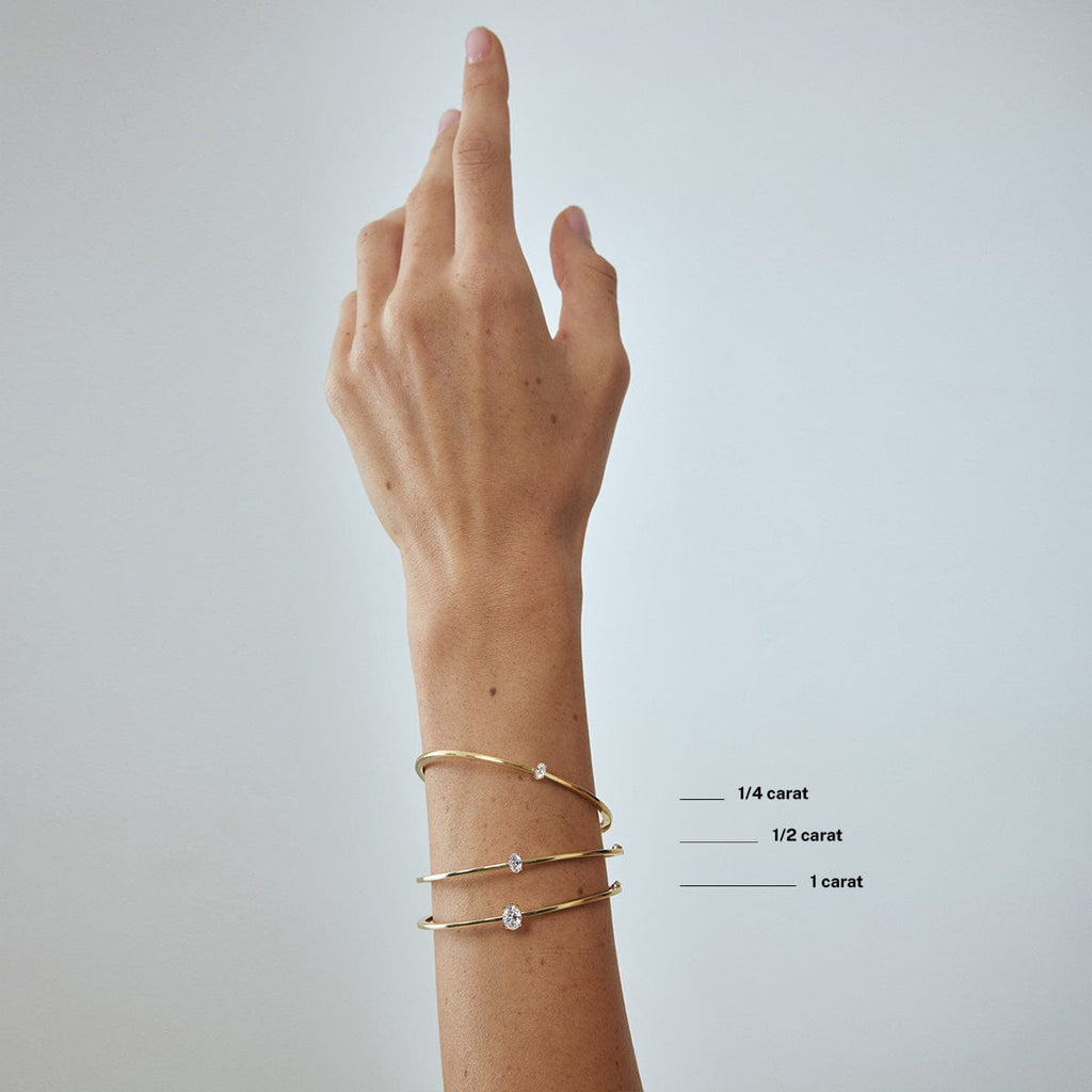 compare oval diamond carat weight bracelets on model's wrist arm