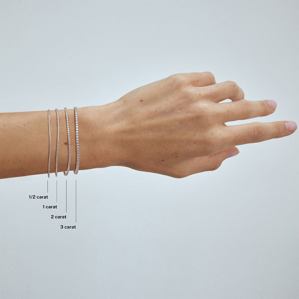 compare 1 carat, 2 carat and 3 carat diamond tennis bracelets on model's wrist arm