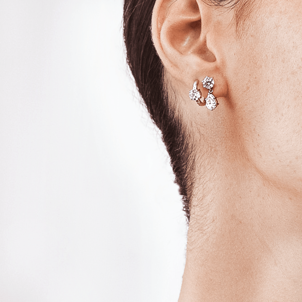 Close-Up of Pear Shaped Diamond Dangling Earrings on Woman's Ear